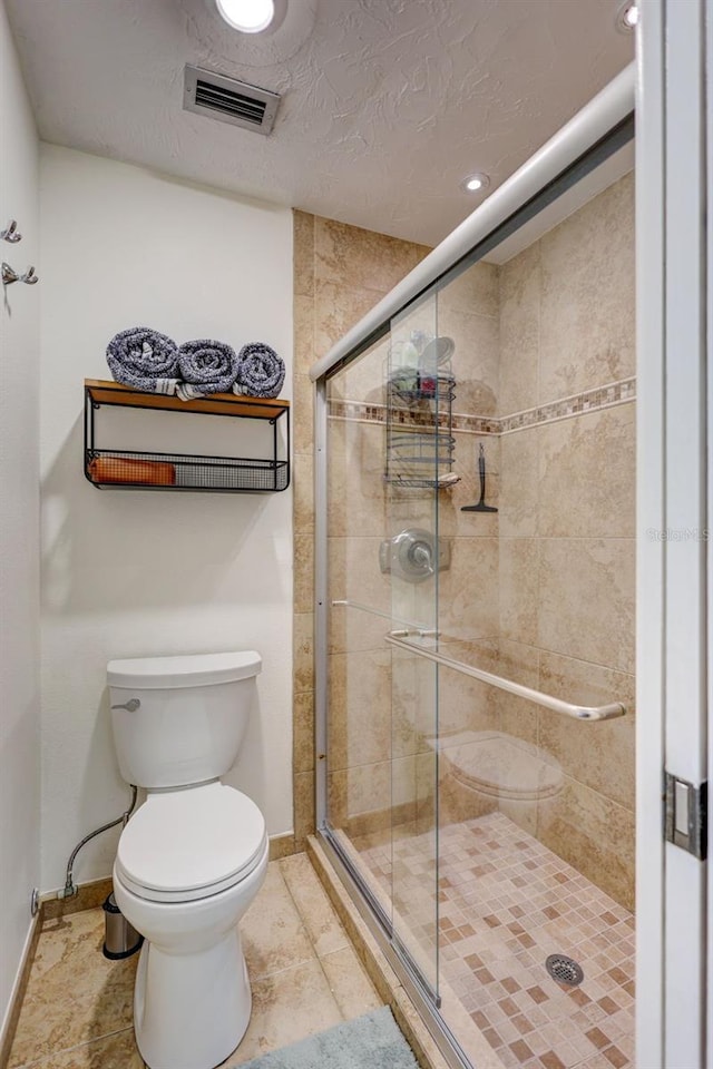 bathroom featuring baseboards, a stall shower, and toilet