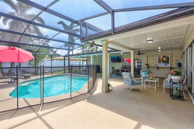 view of pool with a patio, fence, a ceiling fan, and glass enclosure
