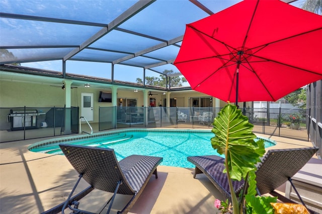 view of swimming pool featuring ceiling fan, a patio area, a lanai, and fence