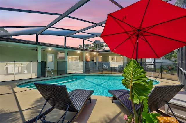 view of pool with a patio area, glass enclosure, and ceiling fan