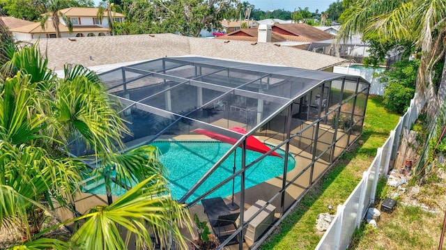 view of pool featuring a patio area, a fenced backyard, and glass enclosure