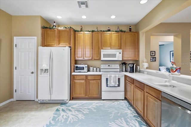 13180 SW Pembroke Cir N, Lake Suzy, FL 34269 - kitchen with white appliances, a sink, brown cabinetry, light countertops, and recessed lighting
