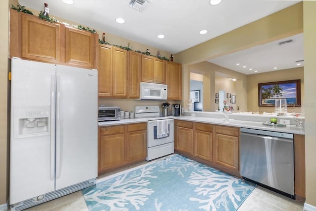 13180 SW Pembroke Cir N, Lake Suzy, FL 34269 - kitchen with white appliances, light countertops, recessed lighting, brown cabinets, and a sink