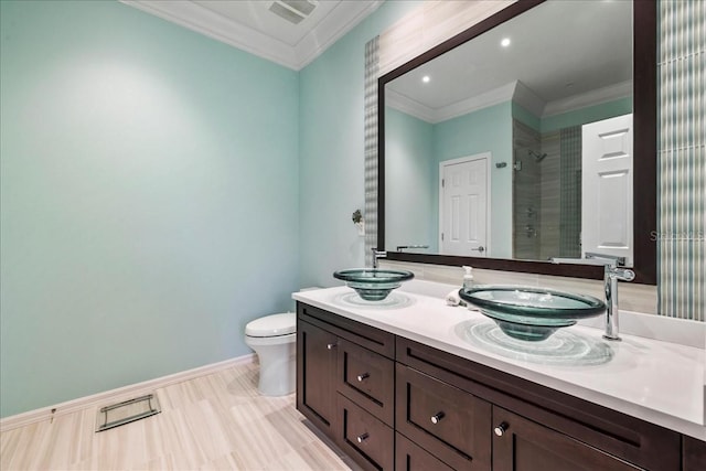 13180 SW Pembroke Cir N, Lake Suzy, FL 34269 - bathroom featuring crown molding, a tile shower, toilet, double vanity, and baseboards