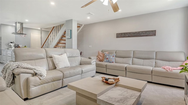 living area featuring a ceiling fan, stairs, light marble finish floors, and recessed lighting