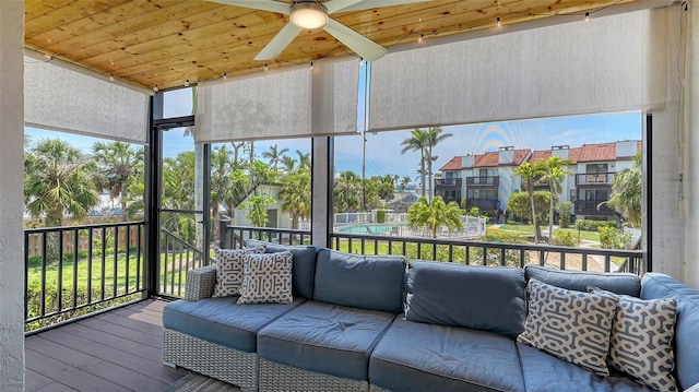 sunroom / solarium featuring a ceiling fan, outdoor lounge area, and a residential view