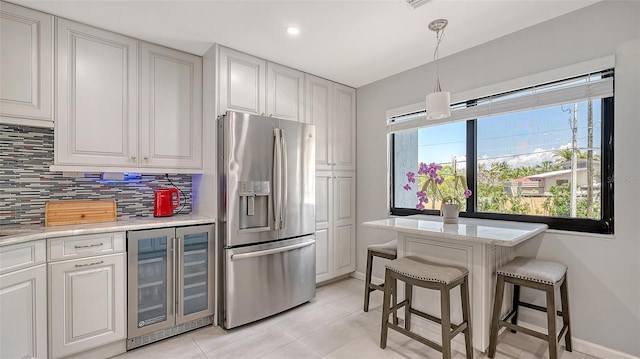 kitchen with stainless steel fridge, beverage cooler, backsplash, baseboards, and recessed lighting