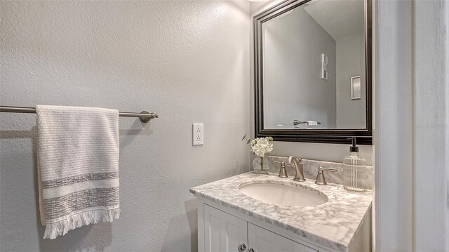 bathroom with vanity and a textured wall