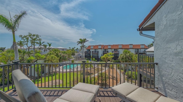 balcony featuring view of pool and a residential view