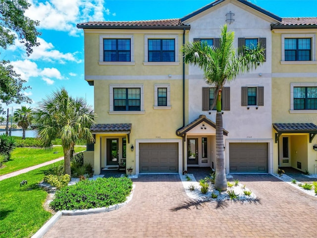 5561 Cannes Cir Unit 5101, Sarasota, FL 34231 - view of front of property with stucco siding, a garage, a tiled roof, and driveway