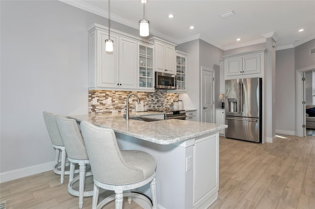 5561 Cannes Cir Unit 5101, Sarasota, FL 34231 - kitchen featuring stainless steel appliances, a sink, a peninsula, light wood finished floors, and light stone countertops