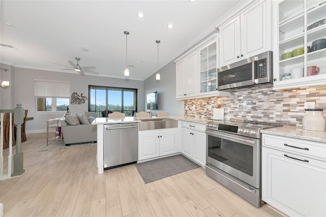 5561 Cannes Cir Unit 5101, Sarasota, FL 34231 - kitchen with stainless steel appliances, a sink, a ceiling fan, ornamental molding, and backsplash