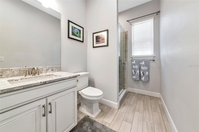5561 Cannes Cir Unit 5101, Sarasota, FL 34231 - bathroom with a stall shower, vanity, toilet, baseboards, and wood finish floors