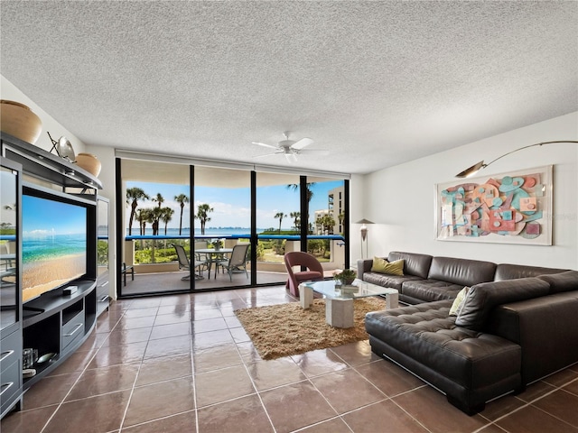 2120 Harbourside Dr Unit 617, Longboat Key, FL 34228 - living room with ceiling fan, dark tile patterned flooring, a textured ceiling, and a wall of windows