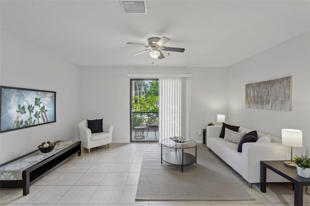 living area featuring ceiling fan, light tile patterned flooring, and baseboards