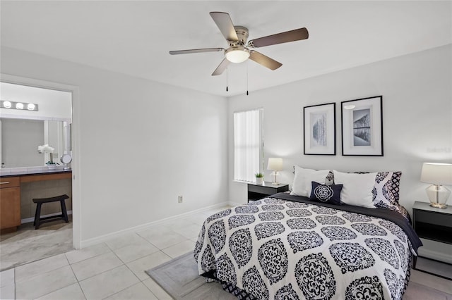 bedroom with light tile patterned flooring, ensuite bath, a ceiling fan, and baseboards