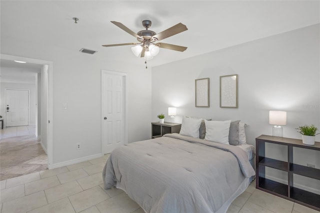 bedroom featuring baseboards, light tile patterned flooring, and a ceiling fan