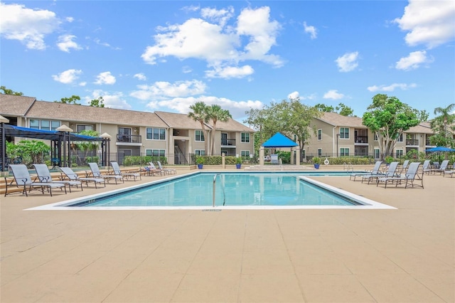 community pool featuring a patio and fence