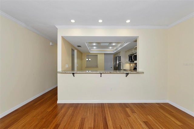 4471 Atwood Cay Cir Unit 13, Sarasota, FL 34233 - kitchen featuring appliances with stainless steel finishes, wood finished floors, crown molding, baseboards, and recessed lighting