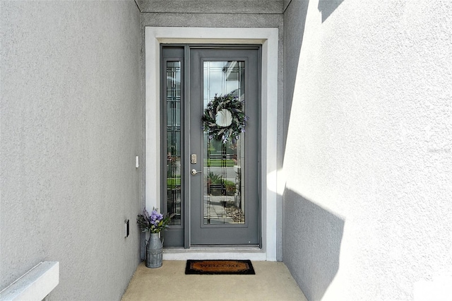view of exterior entry featuring stucco siding