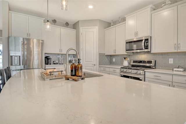 kitchen featuring stainless steel appliances, tasteful backsplash, and white cabinetry