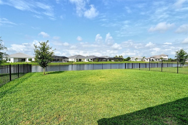 view of yard with a residential view and a water view