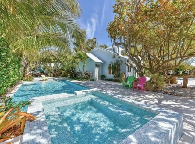 102 48th St, Holmes Beach, FL 34217 - view of swimming pool featuring a pool with connected hot tub and a patio