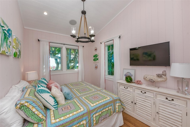 102 48th St, Holmes Beach, FL 34217 - bedroom featuring a chandelier, crown molding, light wood-type flooring, and lofted ceiling