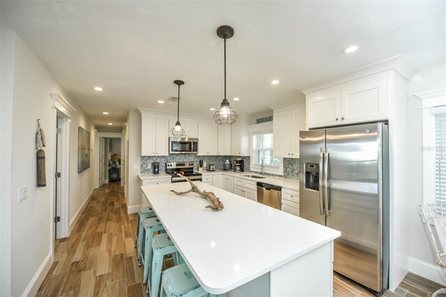 102 48th St, Holmes Beach, FL 34217 - kitchen featuring stainless steel appliances, a sink, baseboards, decorative backsplash, and recessed lighting