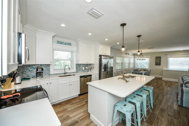 102 48th St, Holmes Beach, FL 34217 - kitchen featuring stainless steel appliances, a sink, healthy amount of natural light, white cabinets, and recessed lighting