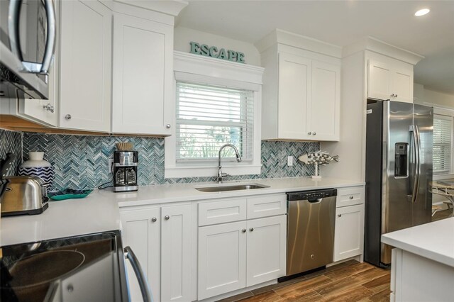 102 48th St, Holmes Beach, FL 34217 - kitchen with appliances with stainless steel finishes, a sink, light countertops, dark wood-style flooring, and white cabinets