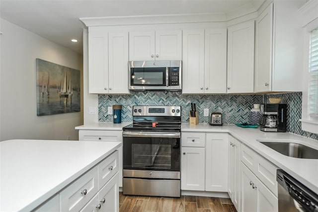 102 48th St, Holmes Beach, FL 34217 - kitchen featuring appliances with stainless steel finishes, tasteful backsplash, light countertops, wood finished floors, and recessed lighting