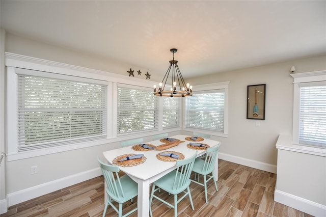 102 48th St, Holmes Beach, FL 34217 - dining room with baseboards, a chandelier, and light wood-style flooring