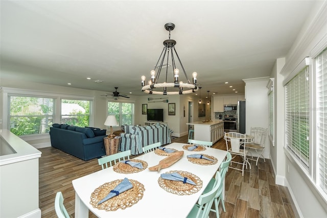 102 48th St, Holmes Beach, FL 34217 - dining space featuring wood finished floors, ceiling fan, a chandelier, recessed lighting, and baseboards