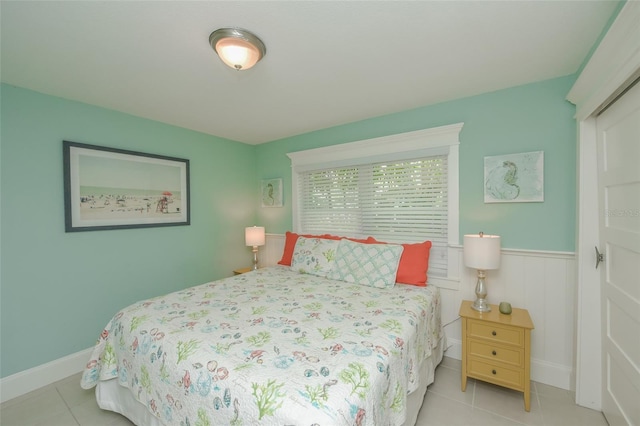 102 48th St, Holmes Beach, FL 34217 - bedroom featuring tile patterned floors, baseboards, and a wainscoted wall