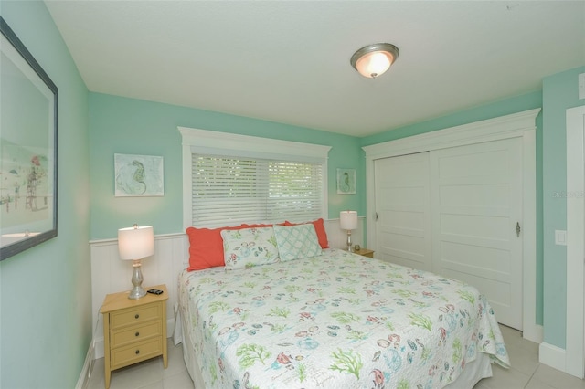 102 48th St, Holmes Beach, FL 34217 - bedroom featuring a closet, light tile patterned floors, and wainscoting