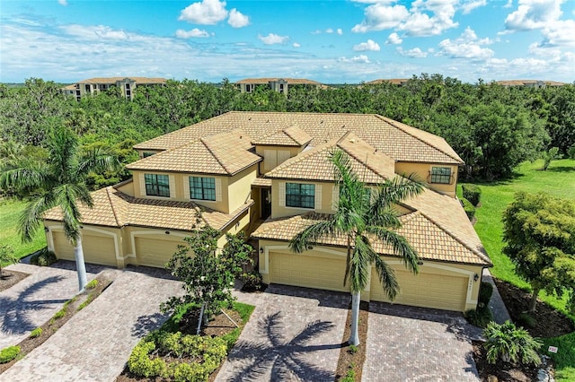 6907 Grand Estuary Trl Unit 104, Bradenton, FL 34212 - mediterranean / spanish-style house featuring decorative driveway, a tile roof, stucco siding, and a garage