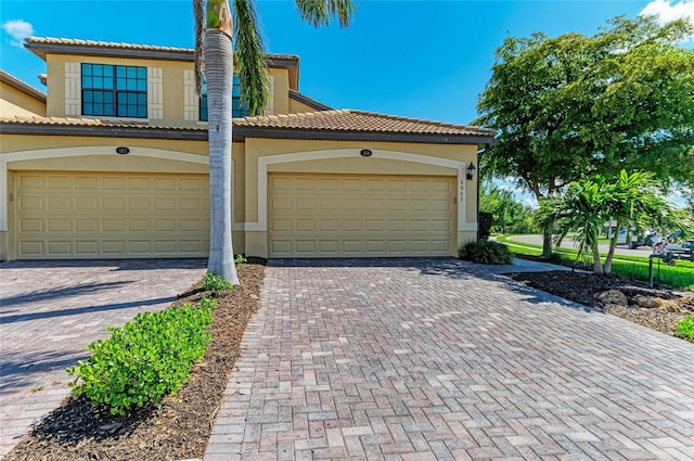 6907 Grand Estuary Trl Unit 104, Bradenton, FL 34212 - view of front facade with stucco siding, decorative driveway, and a garage