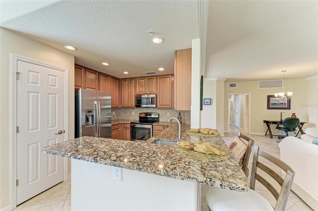 6907 Grand Estuary Trl Unit 104, Bradenton, FL 34212 - kitchen with appliances with stainless steel finishes, a sink, a peninsula, light stone countertops, and light tile patterned flooring
