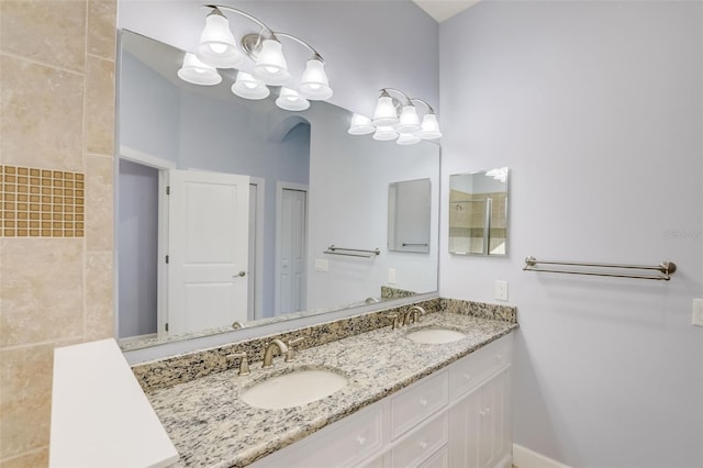 full bathroom with double vanity and baseboards