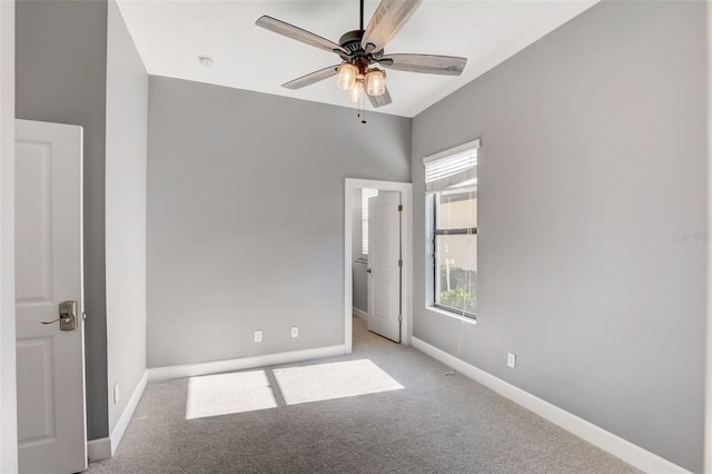 unfurnished room featuring a ceiling fan, baseboards, and light colored carpet