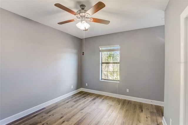 unfurnished room with wood finished floors, baseboards, and a ceiling fan