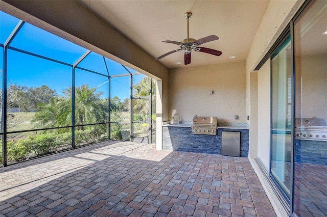 unfurnished sunroom featuring area for grilling, ceiling fan, and a sink