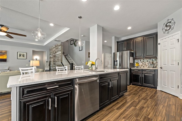 5805 49th Ct E, Ellenton, FL 34222 - kitchen with appliances with stainless steel finishes, a sink, open floor plan, dark cabinetry, and a center island with sink