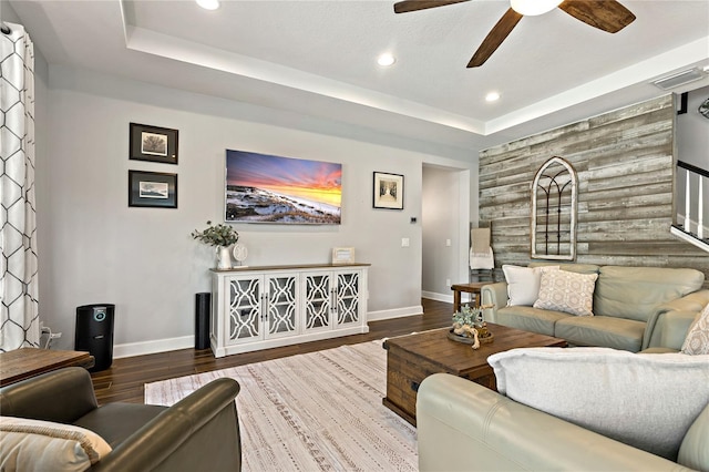 5805 49th Ct E, Ellenton, FL 34222 - living room with baseboards, an accent wall, ceiling fan, a tray ceiling, and wood finished floors