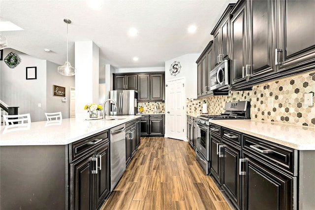 5805 49th Ct E, Ellenton, FL 34222 - kitchen with stainless steel appliances, wood finished floors, light countertops, tasteful backsplash, and pendant lighting