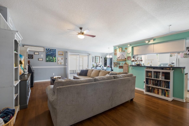 living area featuring ceiling fan, a textured ceiling, wood finished floors, and baseboards