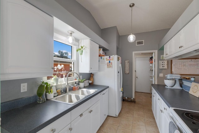 kitchen with dark countertops, a sink, vaulted ceiling, white appliances, and white cabinets