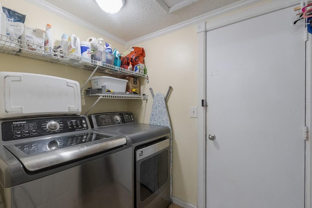 washroom featuring washer and dryer, ornamental molding, and a textured ceiling