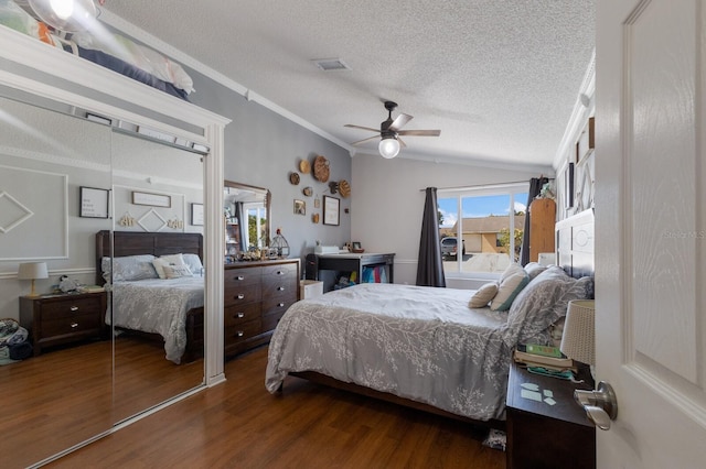 bedroom with wood finished floors, a textured ceiling, ornamental molding, a ceiling fan, and lofted ceiling